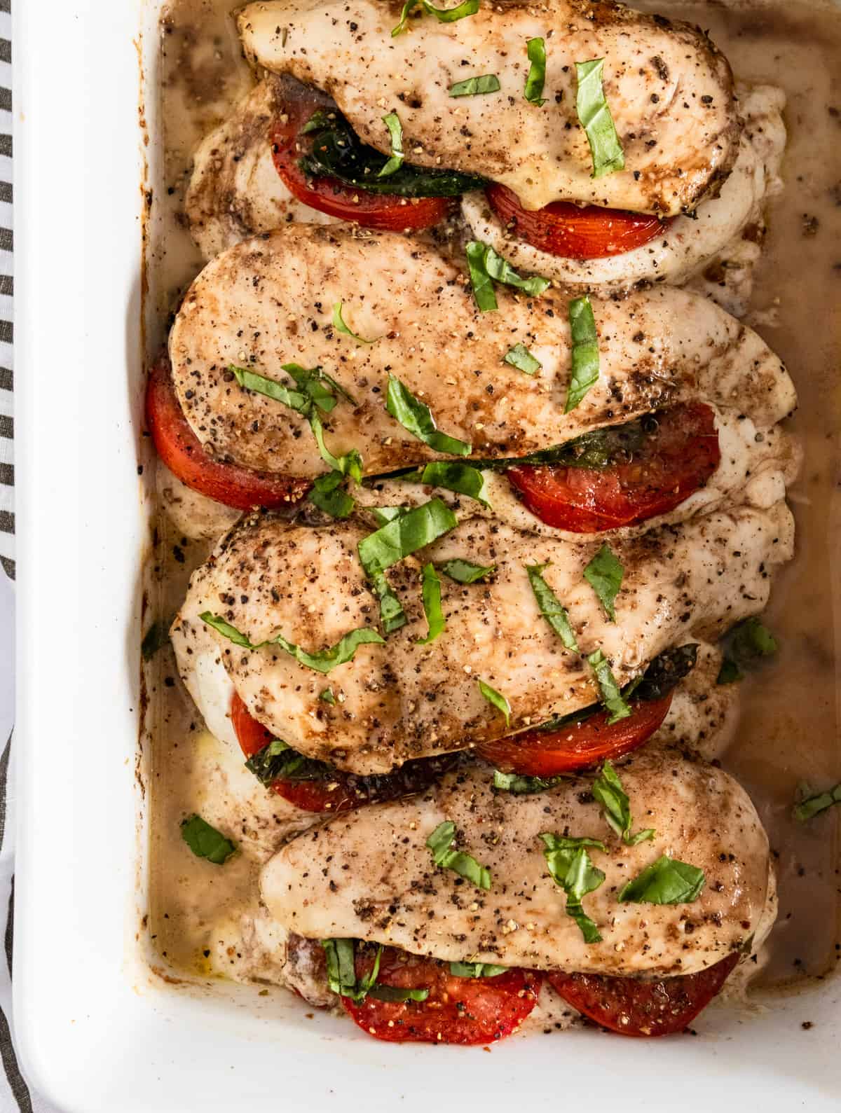 Cooked mozarrella stuffed chicken with chopped basil on top.