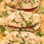 Close up view of stuffed chicken breasts topped with freshly chopped basil.