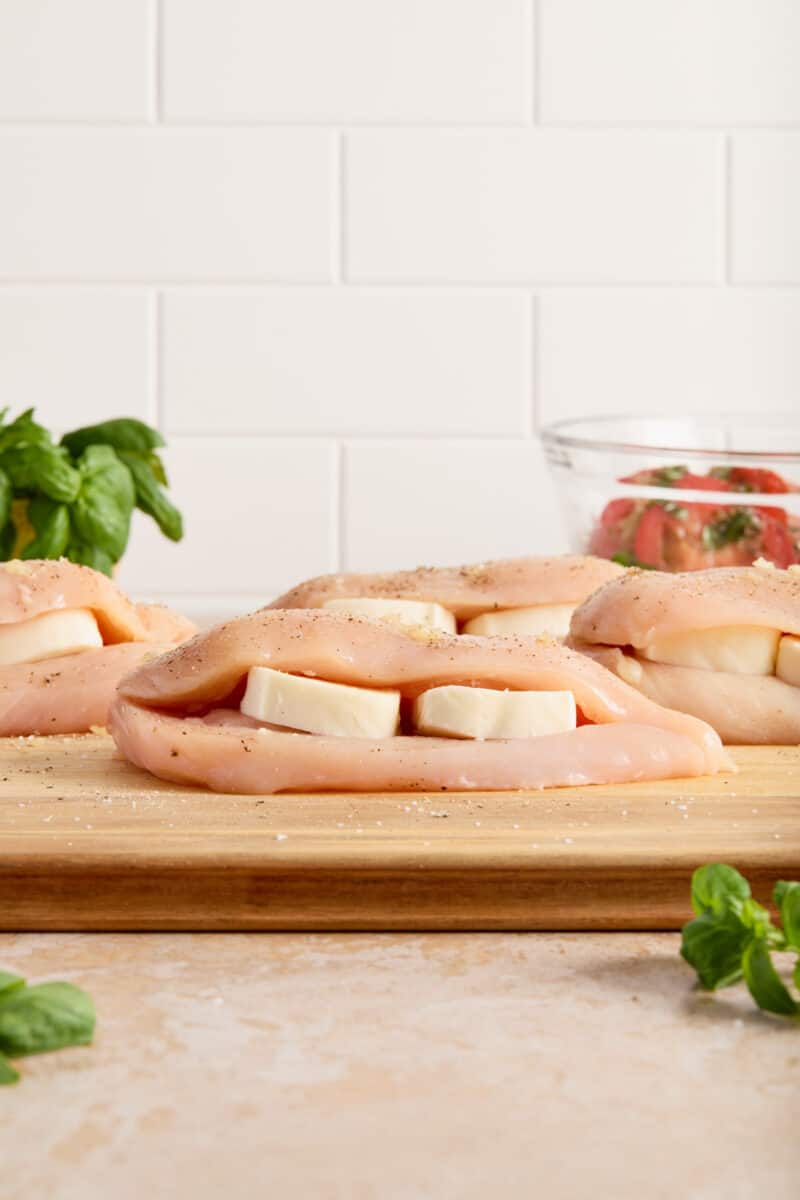 Mozzarella slices stuffed inside cut chicken breast before cooking.