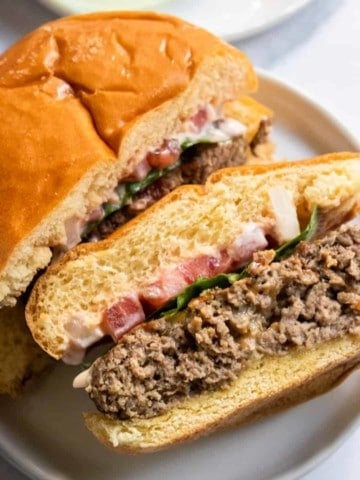 Air fryer hamburger on bun and white plate.