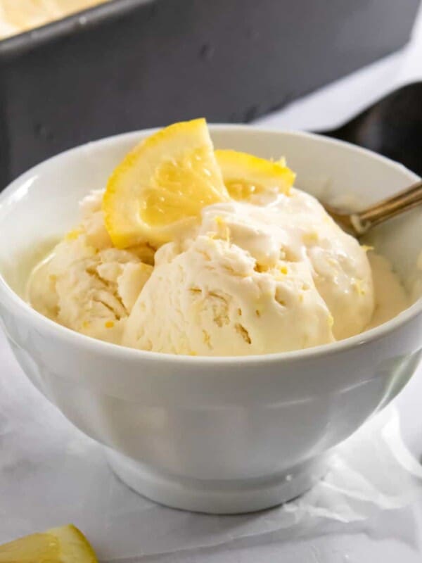 Lemon ice cream in white cup with spoon.