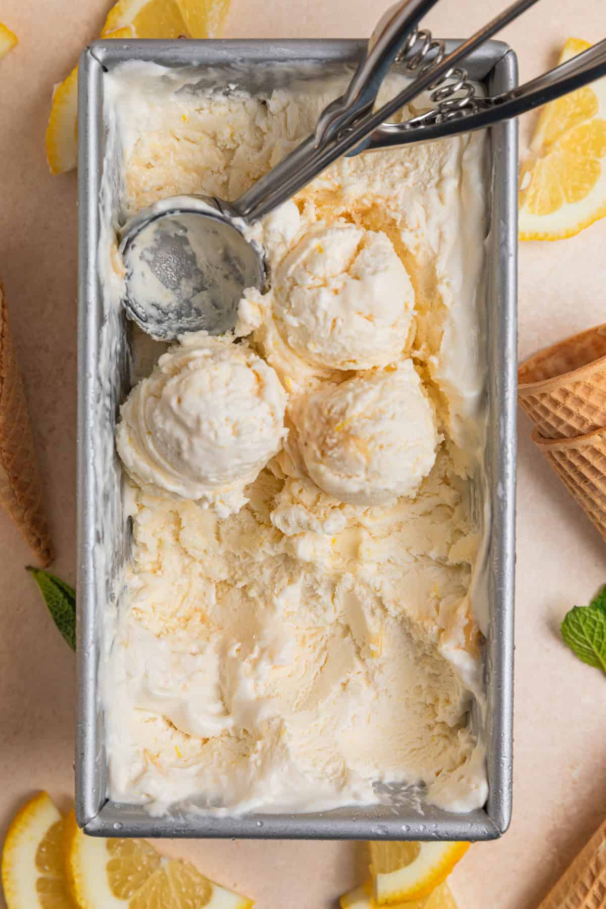 Overhead view of bread pan with scooped lemon ice cream.