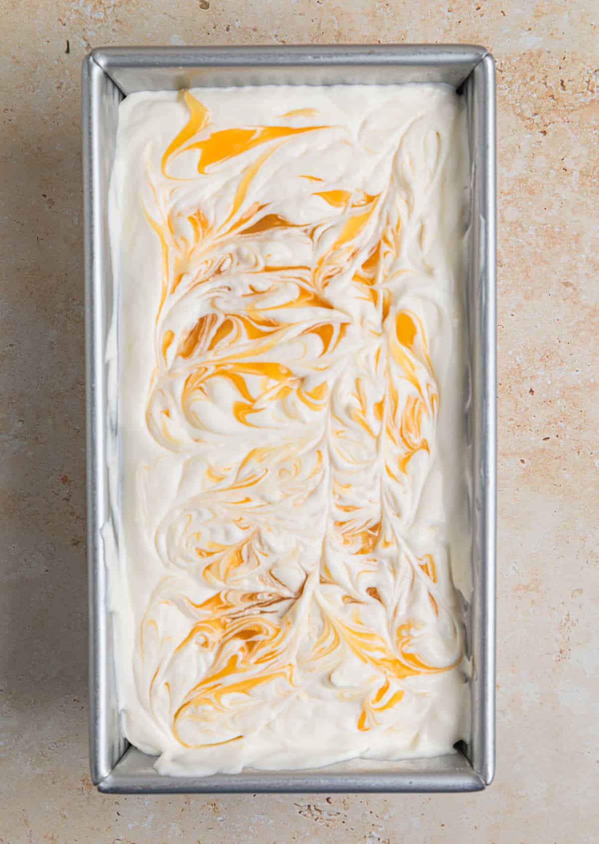 Lemon curd swirled into no churn lemon ice cream mixture before freezing.