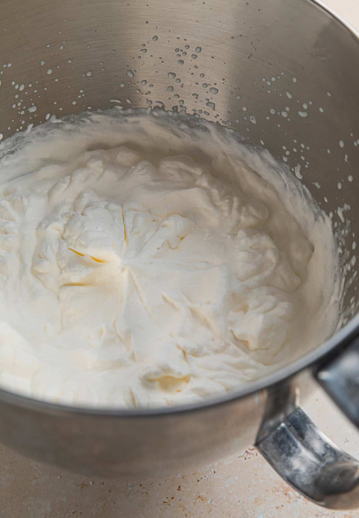 Heavy whipping cream in electric mixer bowl whipped to stiff peaks.