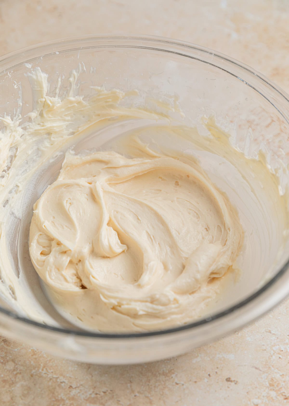Cream cheese can powdered sugar creamed together in glass mixing bowl.