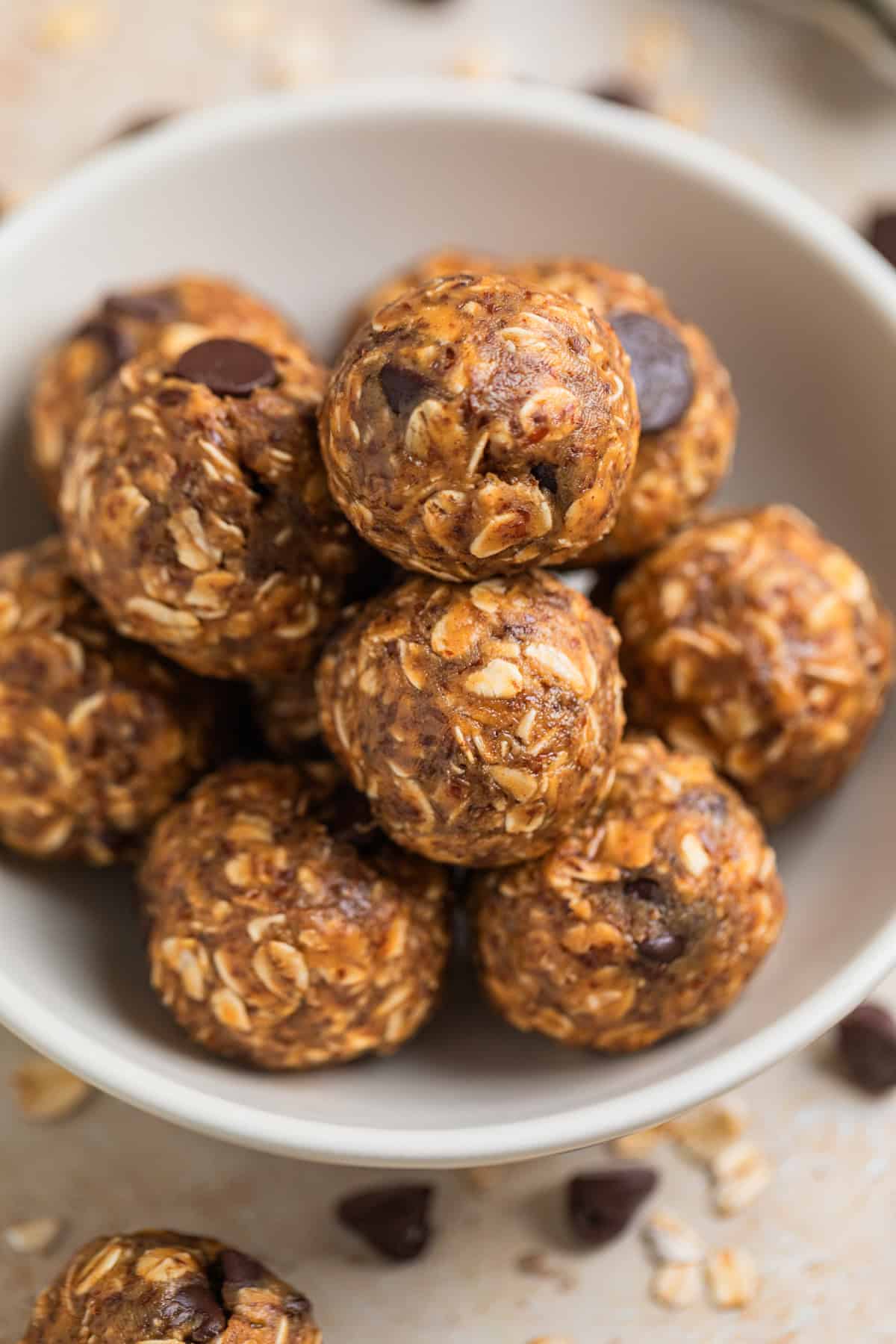 Close up view of oat and peanut butter balls in white dish.