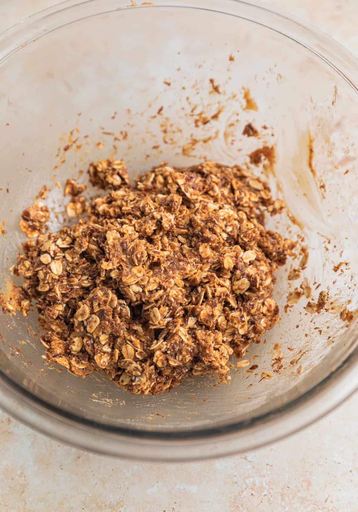 Oat and peanut butter ball mixture in glass bowl.