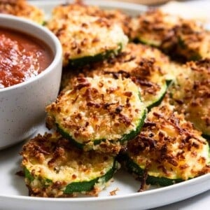 Zucchini with crispy cheese coating on plate.