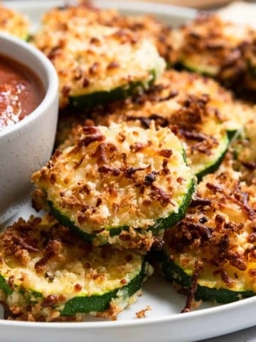 Zucchini with crispy cheese coating on plate.