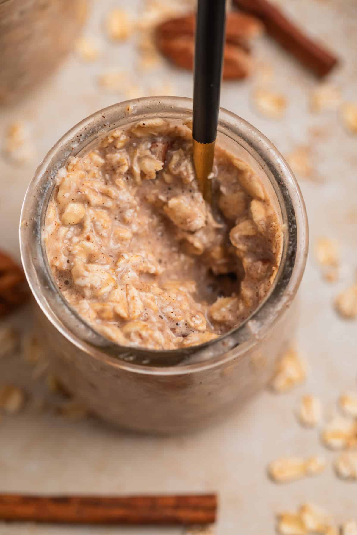 Spoon scooping into jar with banana overnight oats.