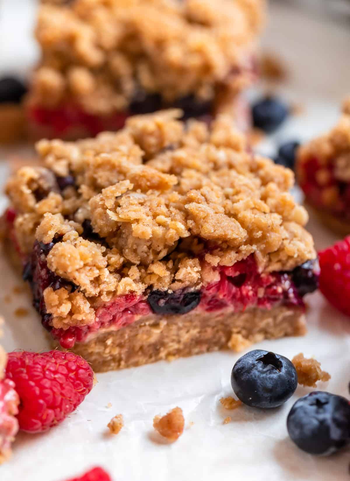 Mixed berry bar on wax paper with blueberries and raspberries surrounding.