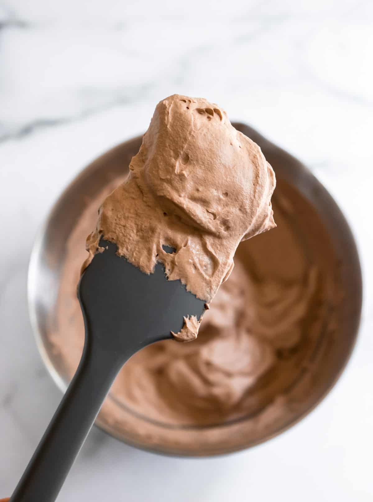 Chocolate whipped cream on spatula.