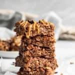 No Bake oat bars stacked with peanut butter drizzle.