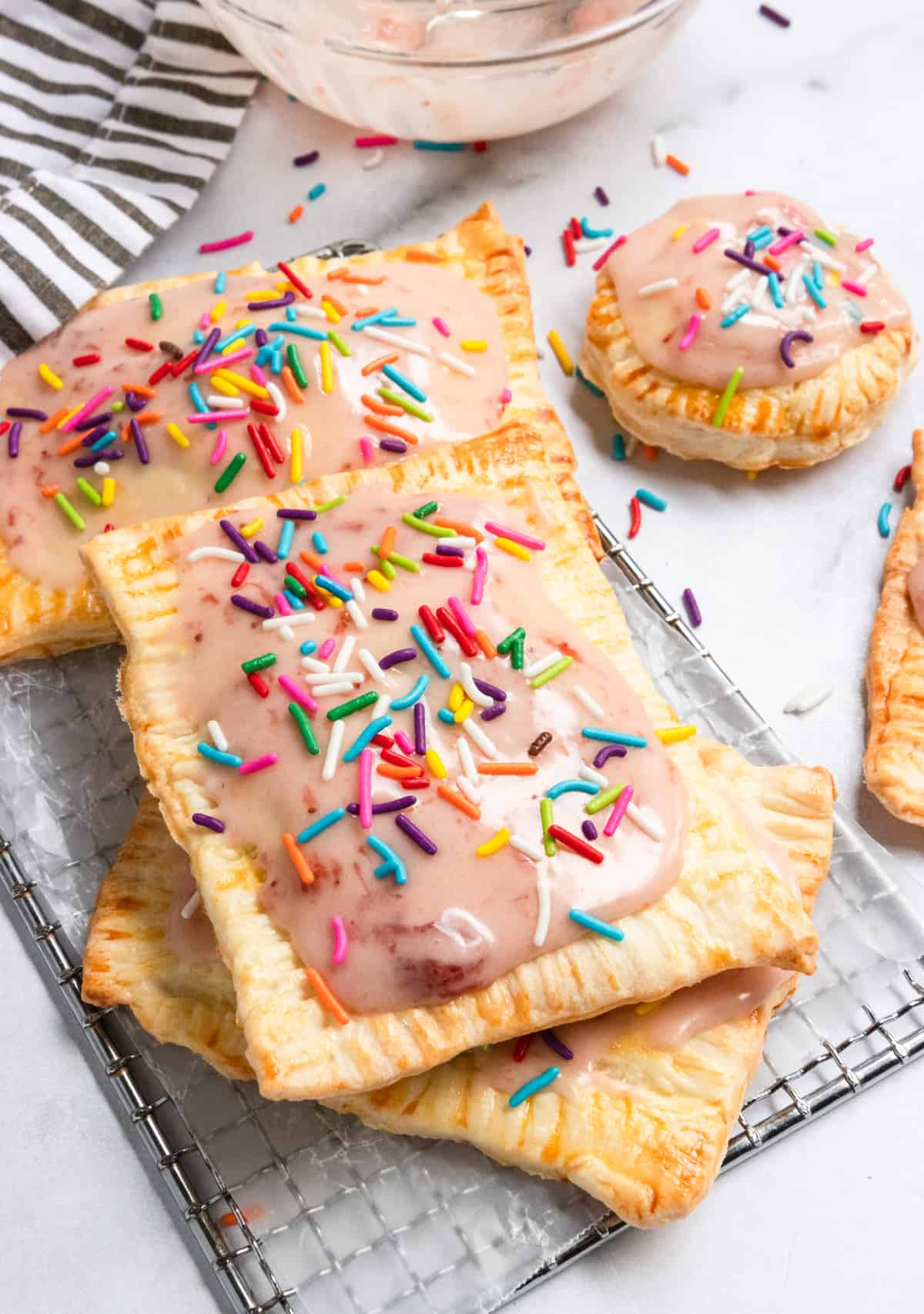 Homemade Pop Tarts on parchment and cooling rack with sprinkles.