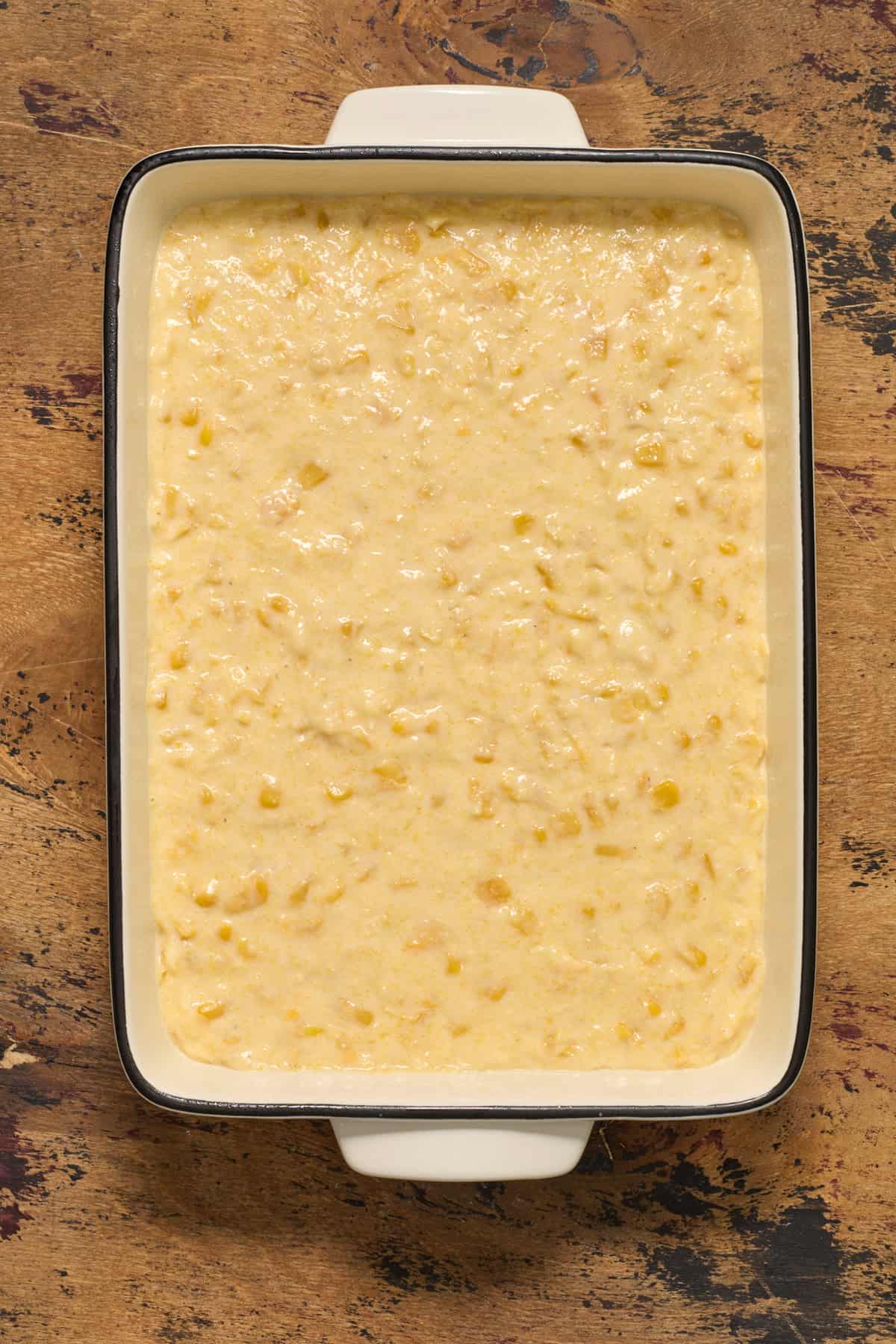 Casserole dish with jiffy sweet cornbread casserole before baked.