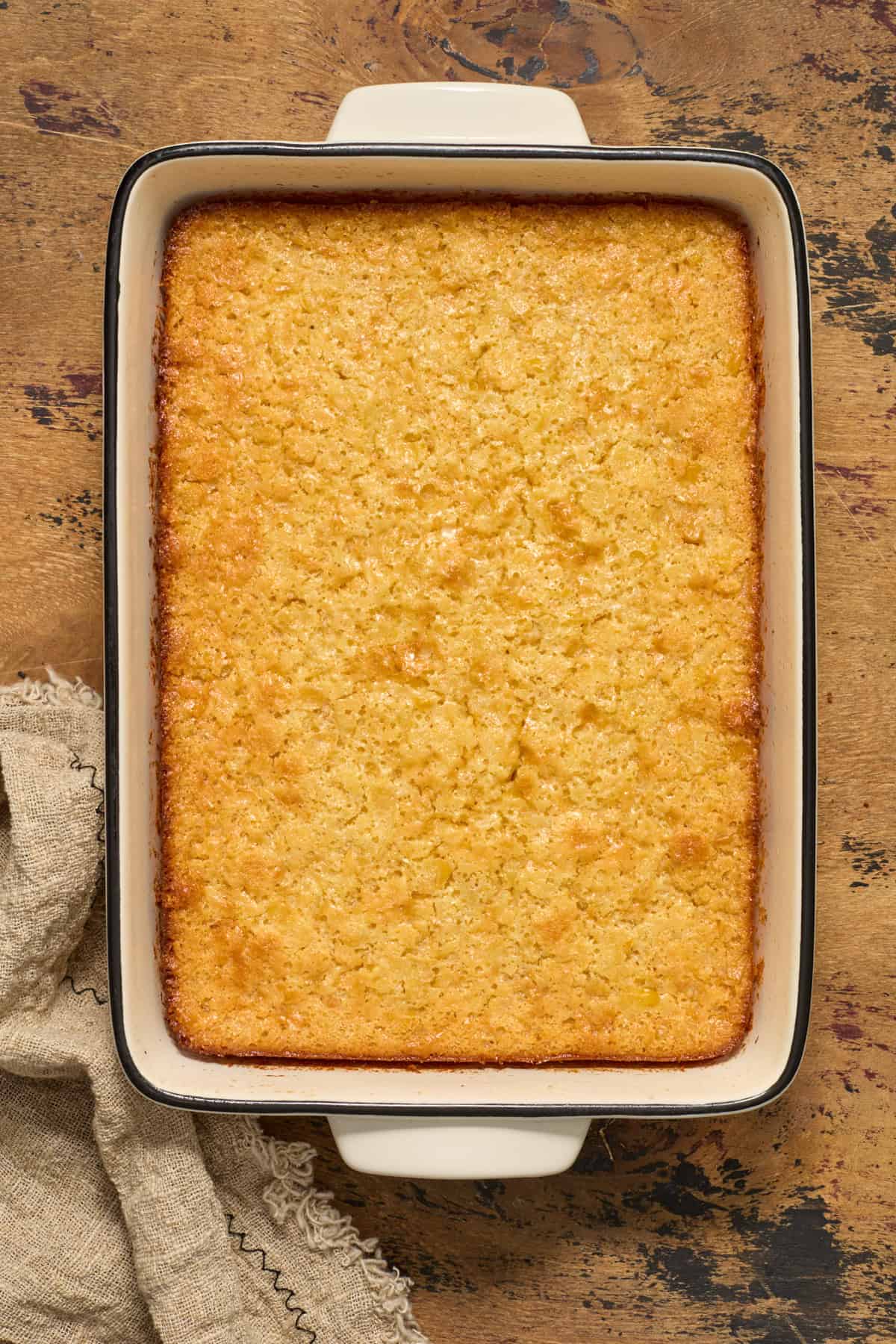 Baked honey cornbread casserole in baking pan.