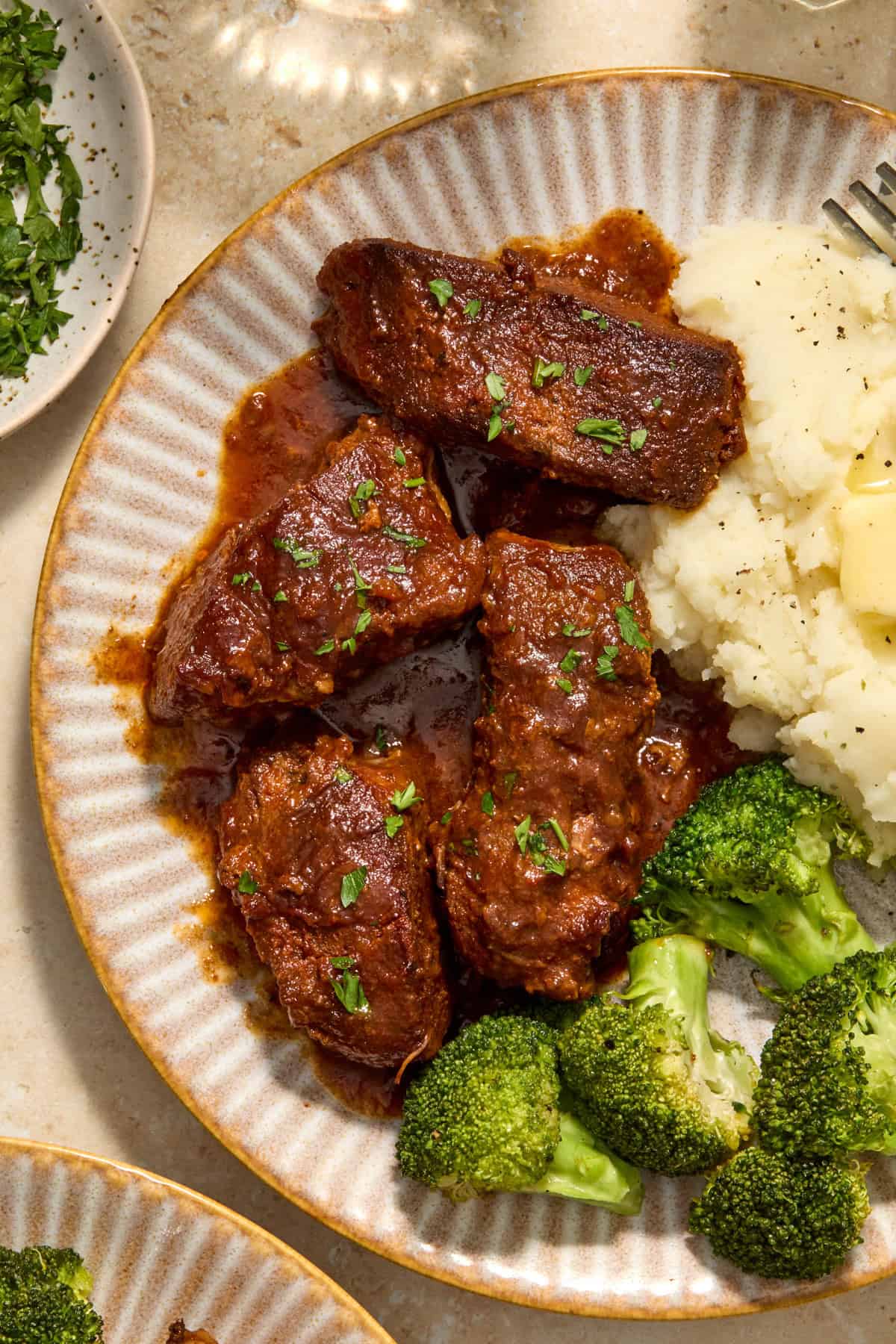 Country style ribs on plate with broccoli and potatoes.