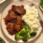 Country style ribs served on plate with bbq sauce.