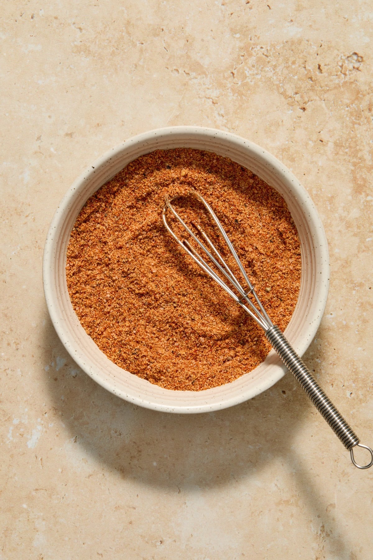 Pork ribs spice rub in bowl with whisk.
