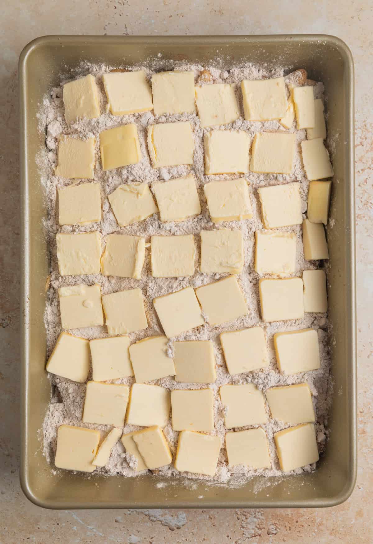 Slices of butter lined to cover spice cake layer in cake pan.