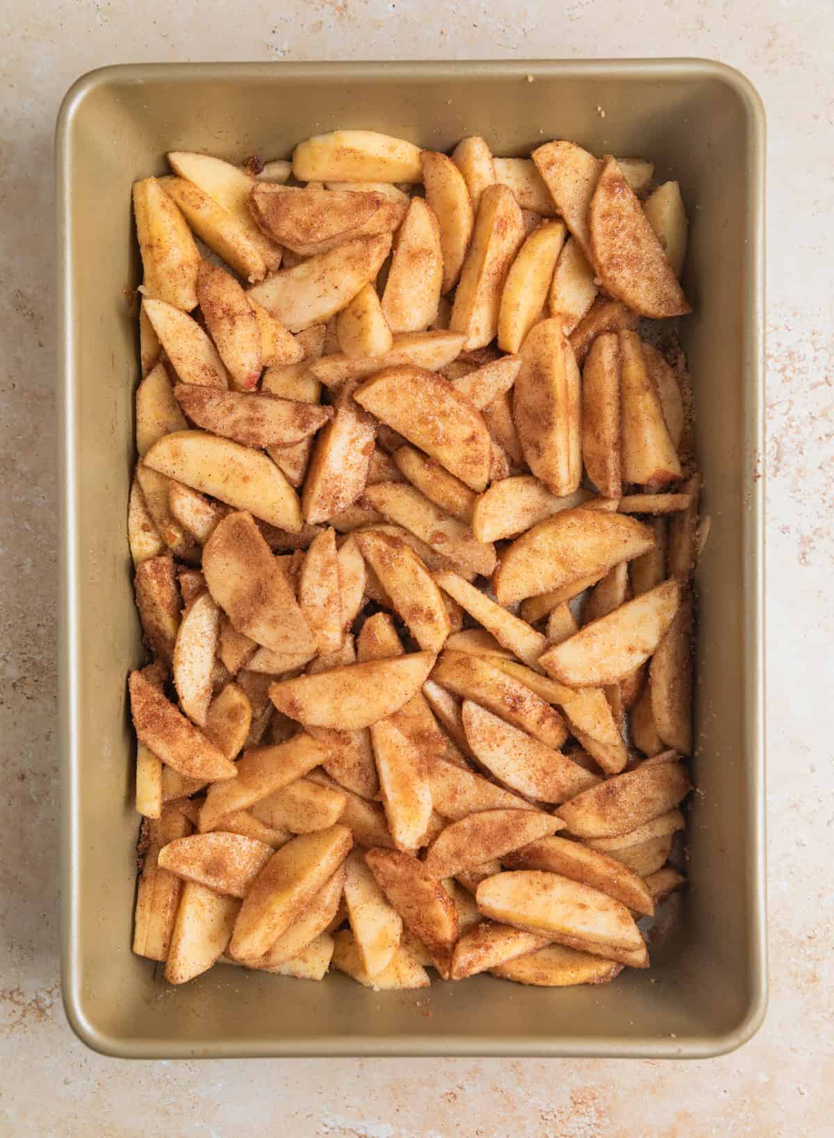 Cinnamon sugar coated apples in baking pan.