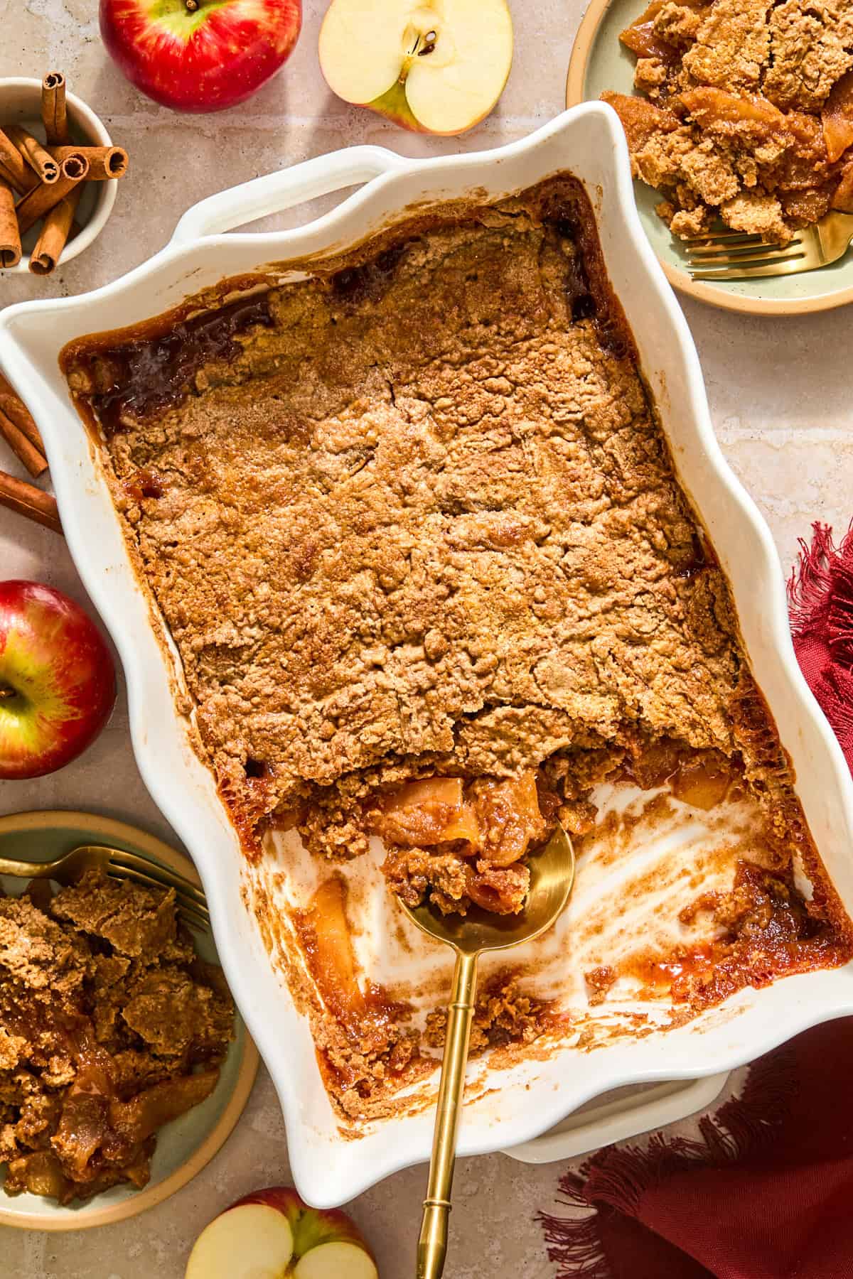Baking pan with apple spice dump cake and serving spoon.