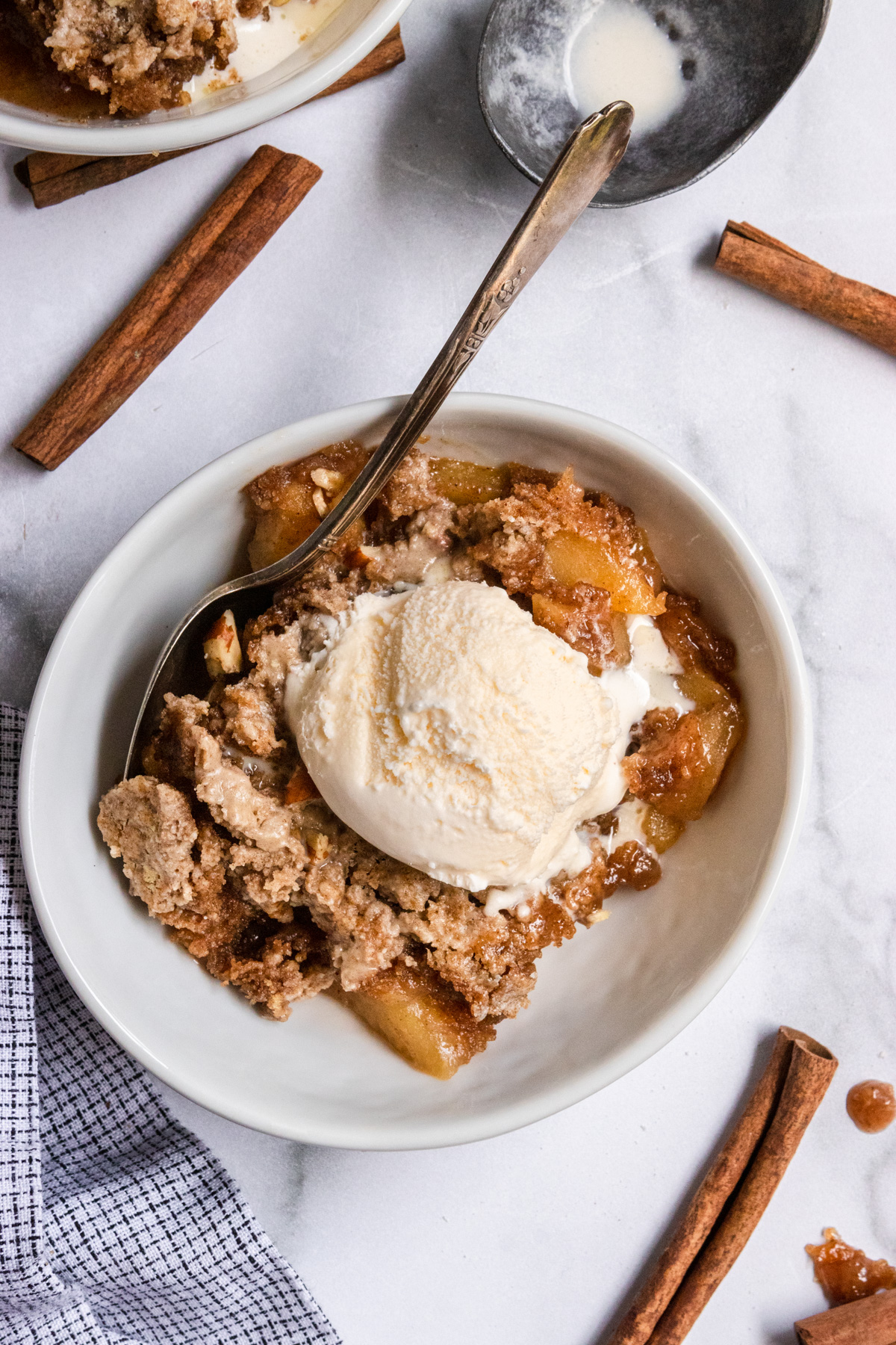 Overhead shot of apple dump cake with ice cream and spoon.