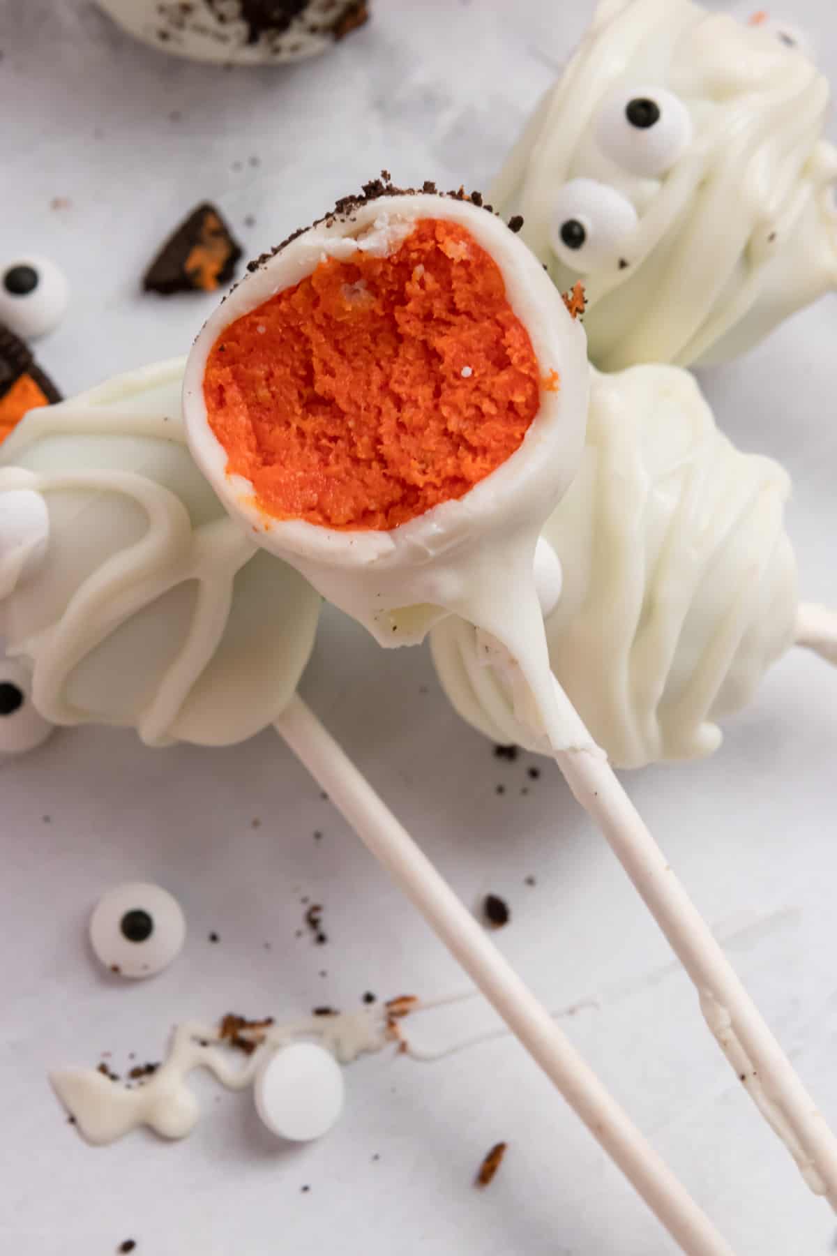 Cake pop with bite taken out to show orange inside.