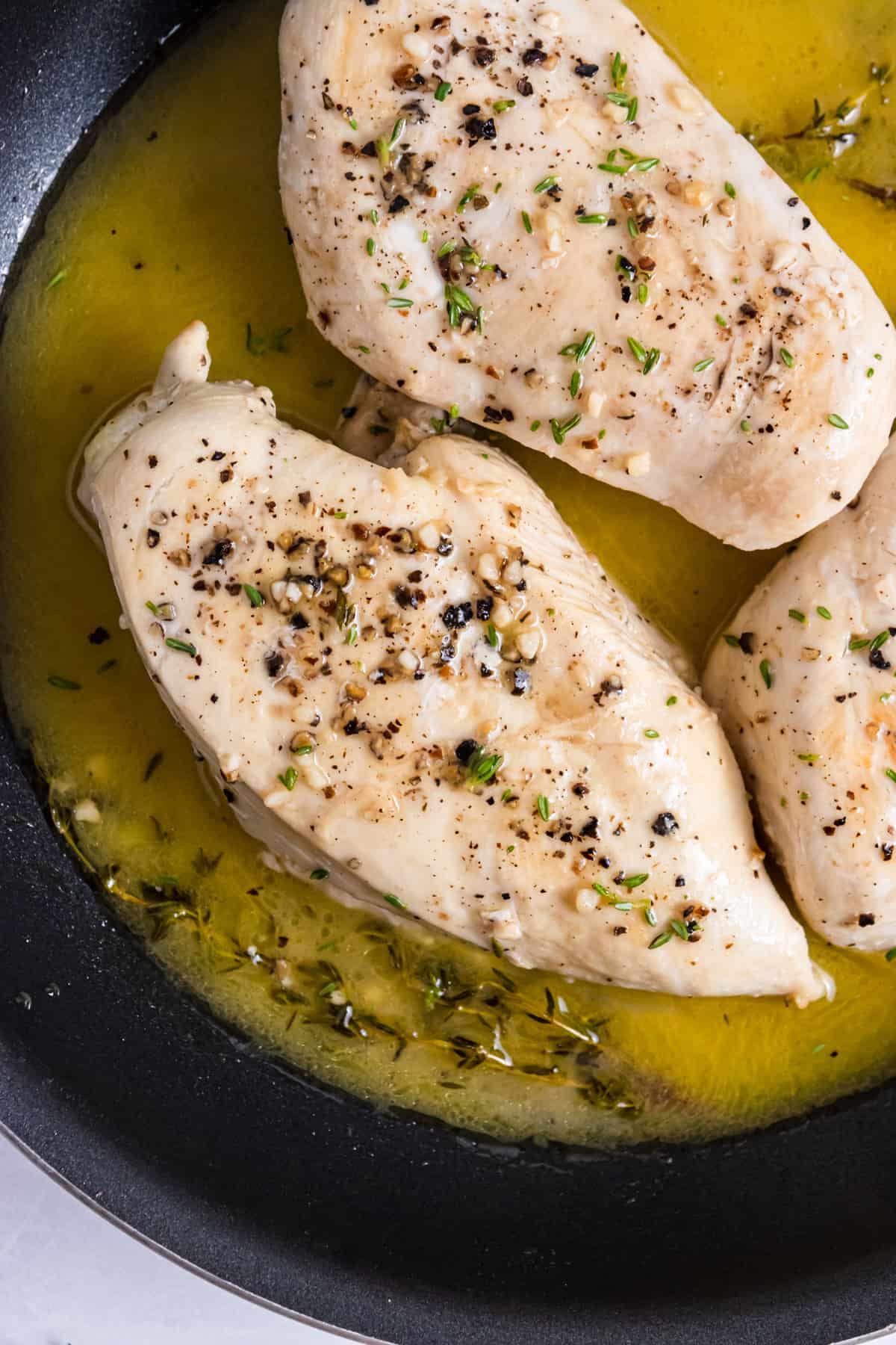 Pan seared chicken with fresh thyme in pan with butter.