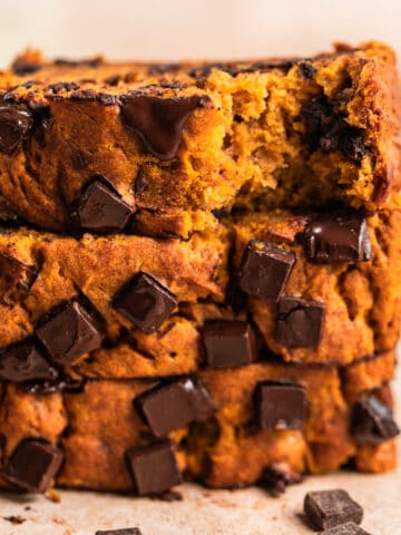 Stack of pumpkin banana bread with chocolate chips slices on top of each other.