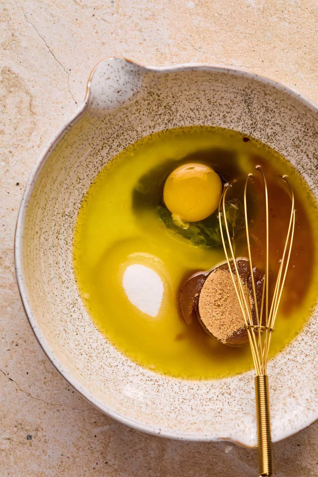 Eggs, butter, molasses and other ingredients in bowl with whisk.