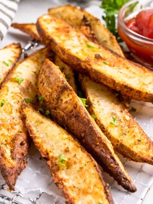 Crispy air fried potato wedges with ketchup.