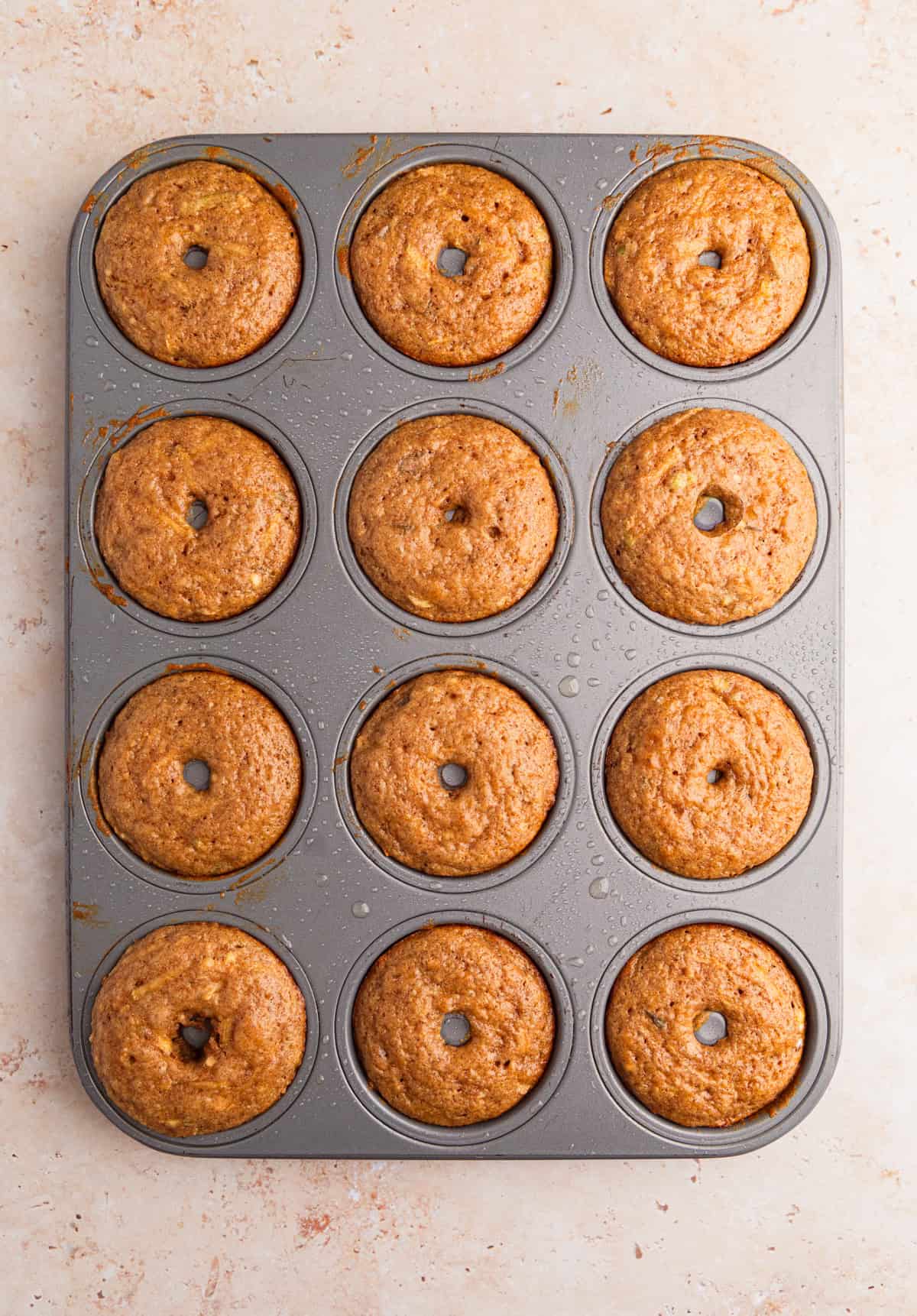 Baked donuts with apples in donut pan.