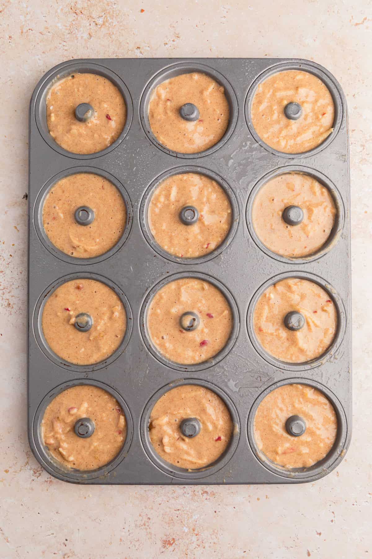 Apple cinnamon donut batter in donut pan.