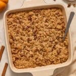 Square baking pan with butternut squash casserole topped with pecan crumble.
