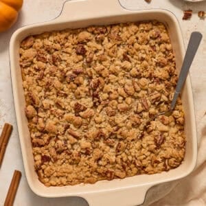 Square baking pan with butternut squash casserole topped with pecan crumble.