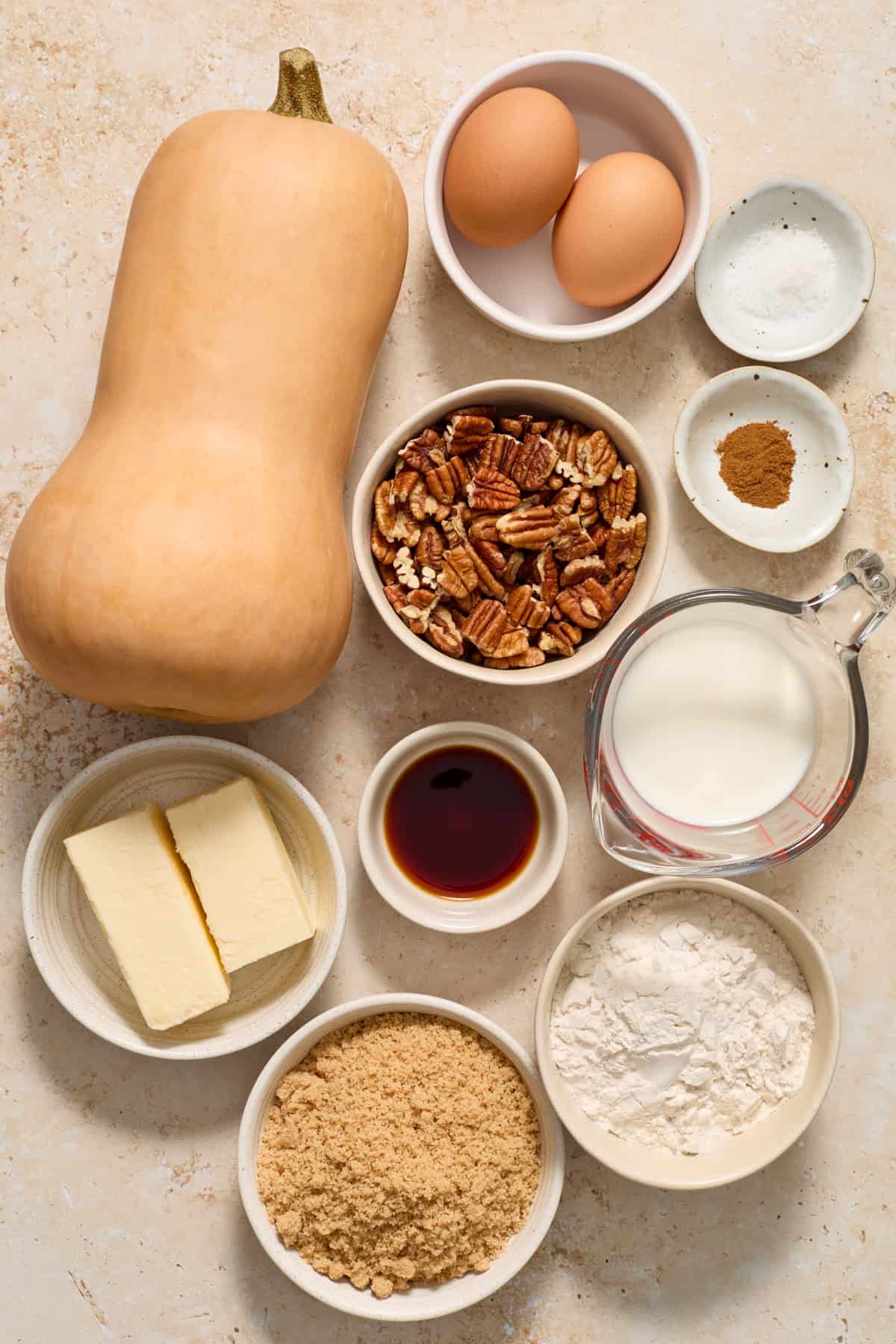 Butternut squash, eggs, flour, brown sugar and more on surface.