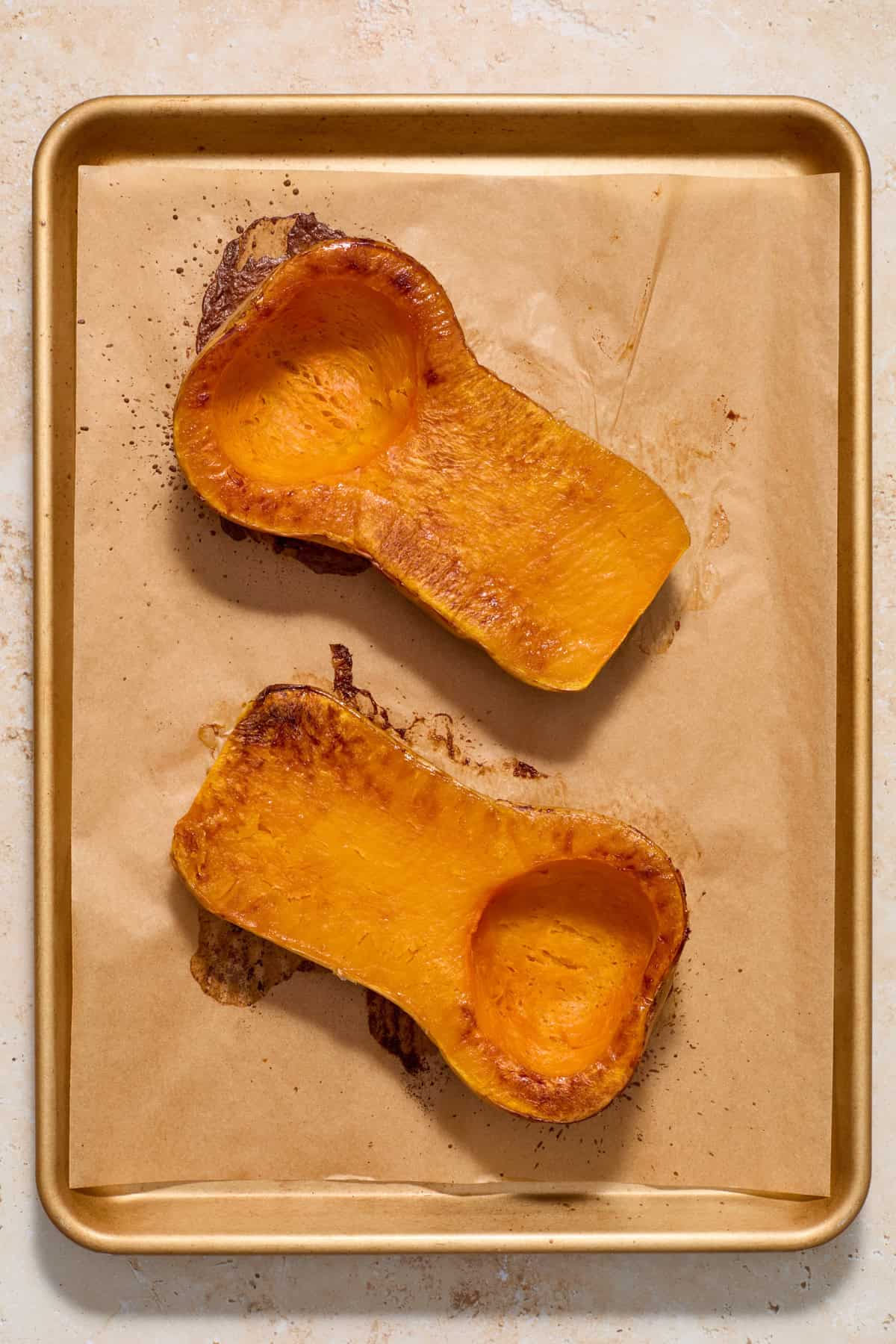 Baked butternut squash on parchment lined baking sheet.