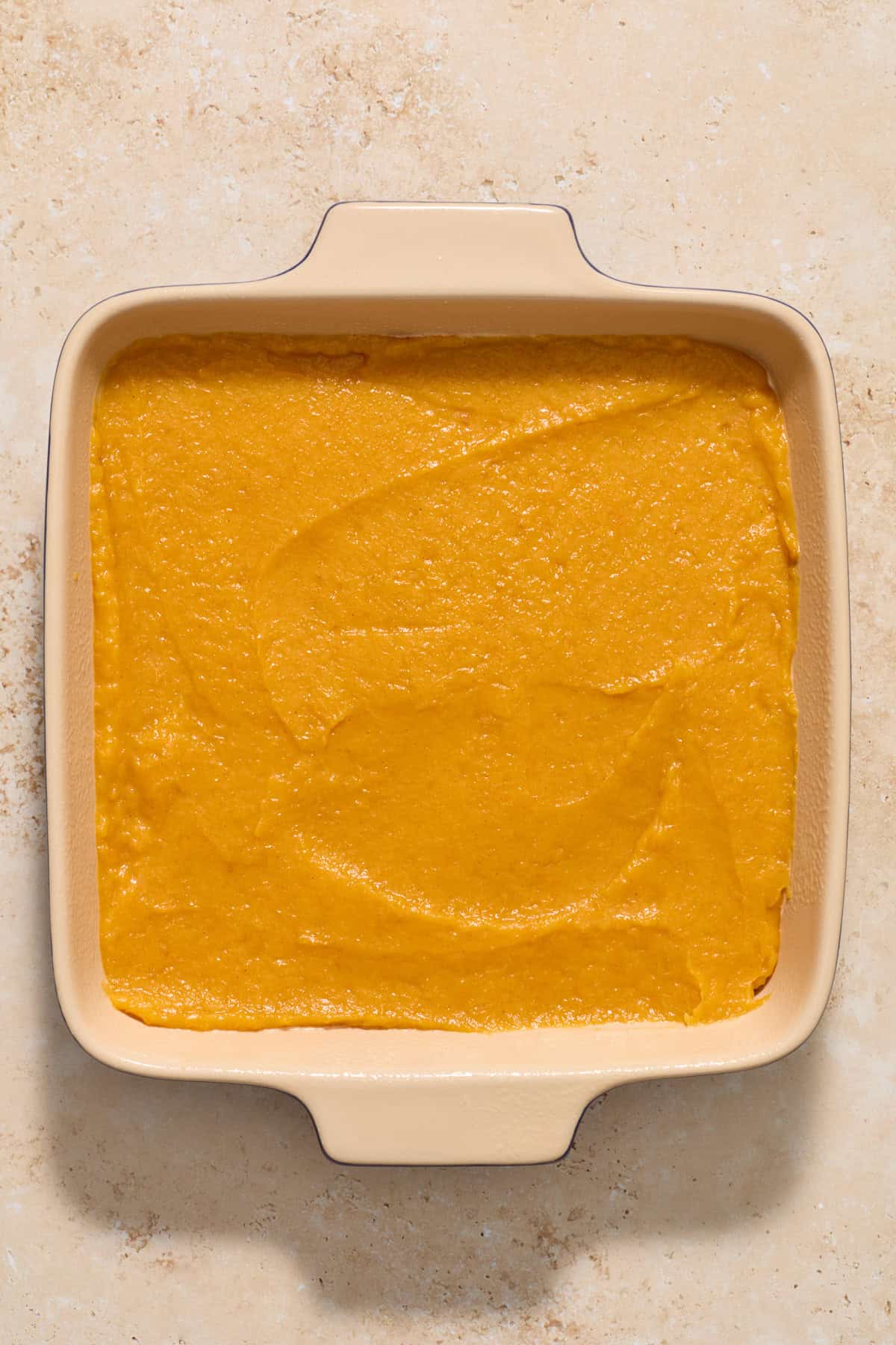 Nine inch baking pan with squash mixture spread evenly within.