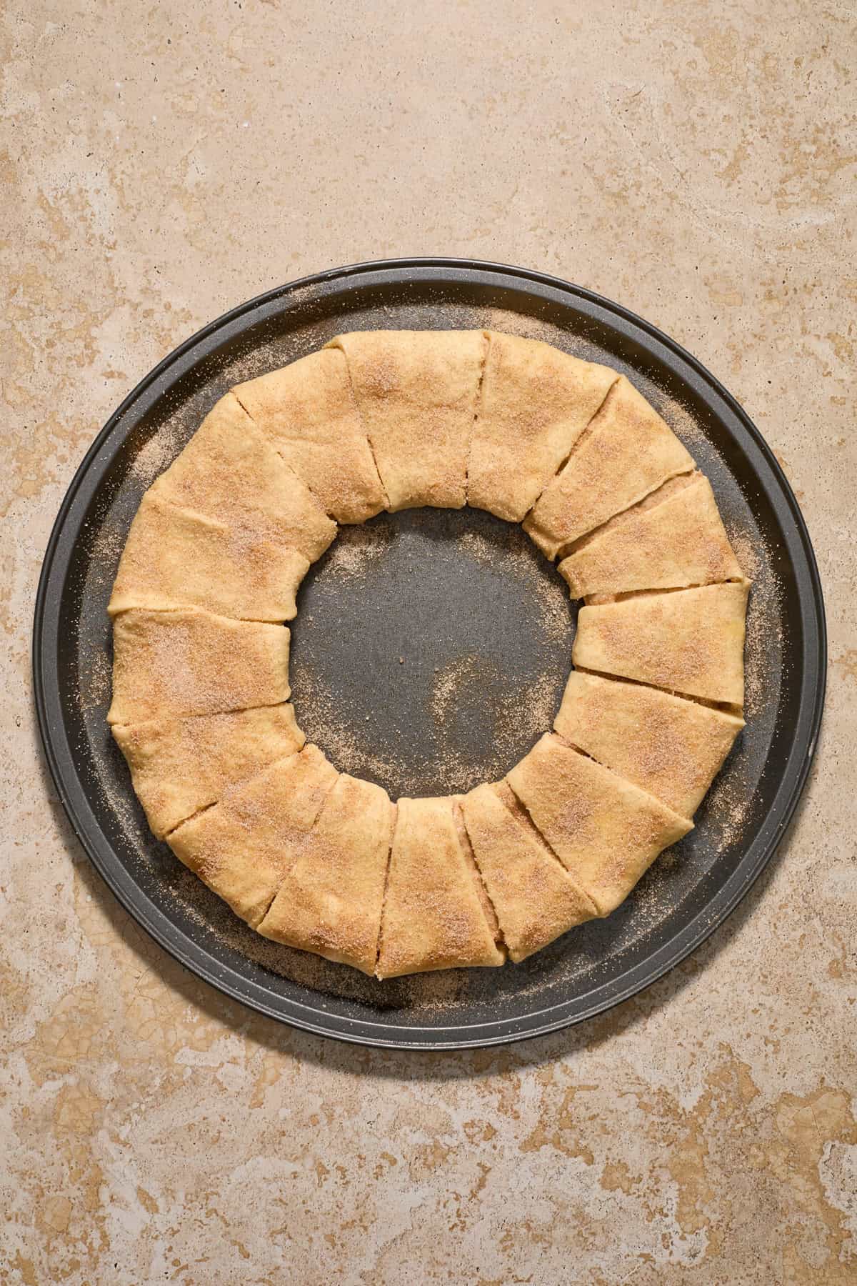 Cinnamon and sugar sprinkled over top of dough formed into circle.