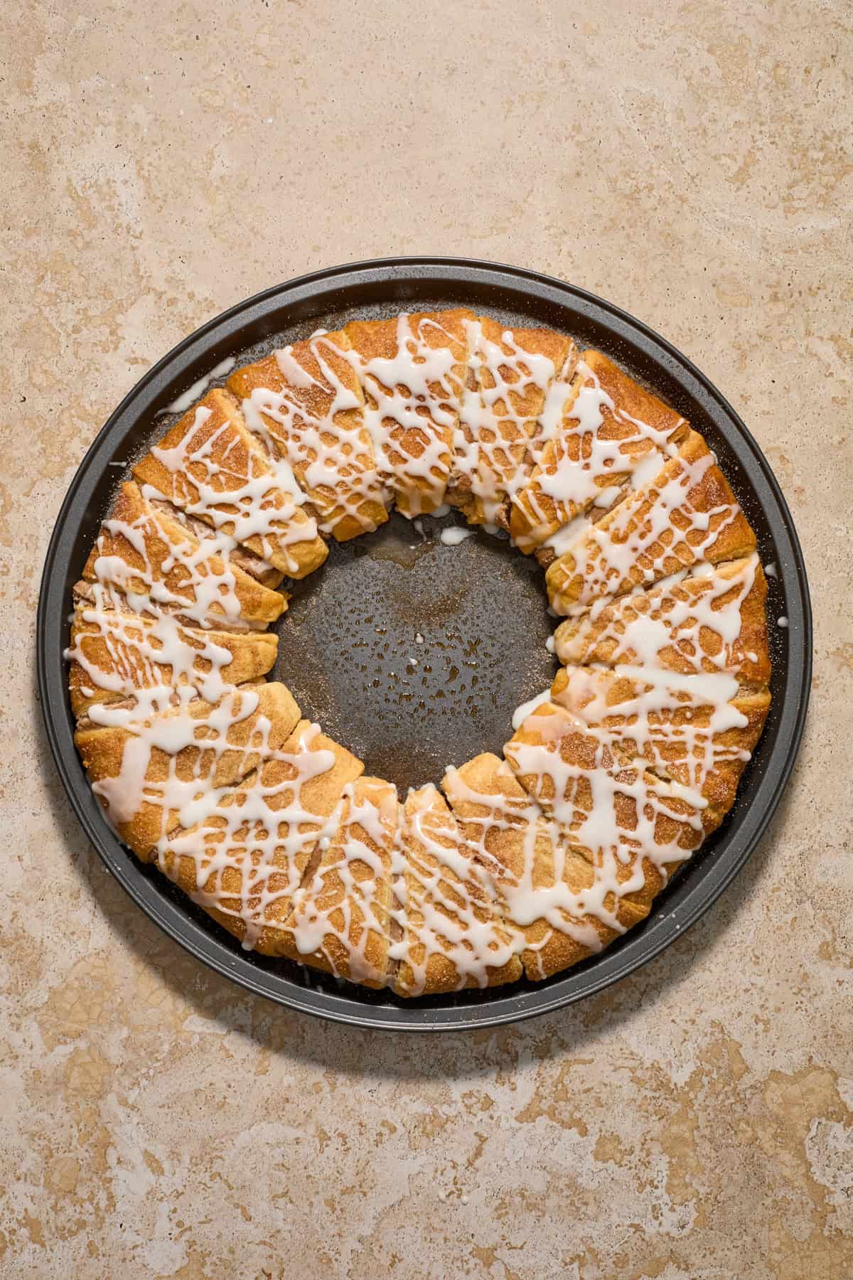 Baked cinnamon cream cheese pastry on pan freshly iced.