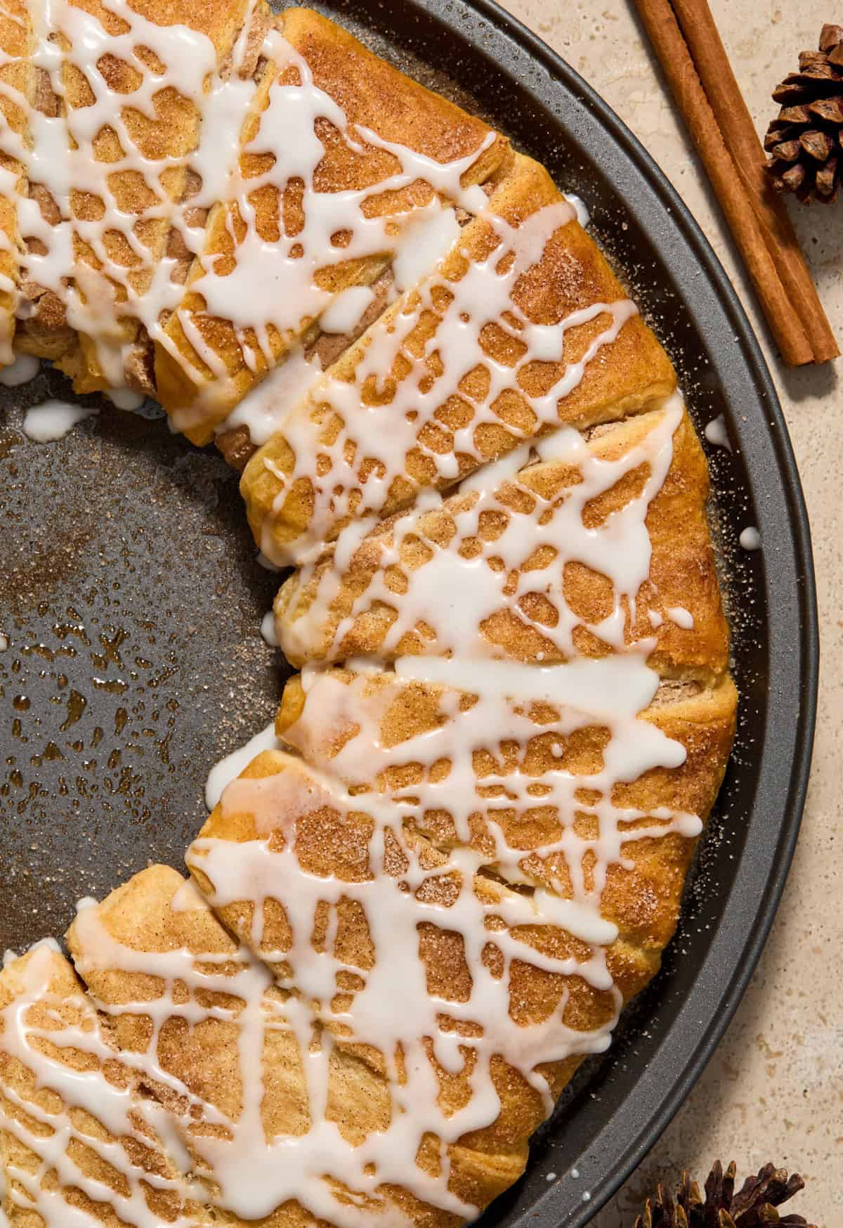 Close up view of cinnamon crescent wreath with icing drizzle over top.