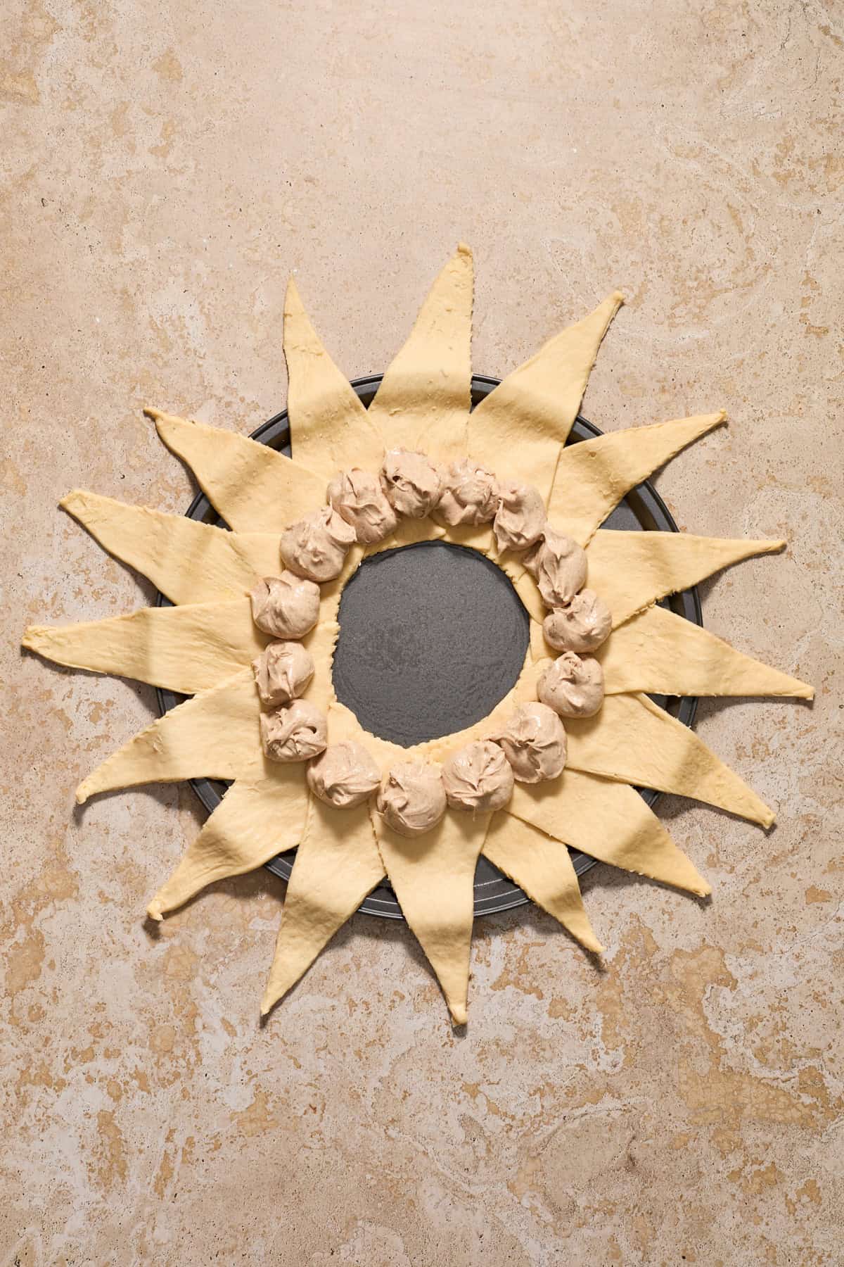 Cinnamon cream cheese mixture spooned into the center of crescent triangles arranged to form a circle.