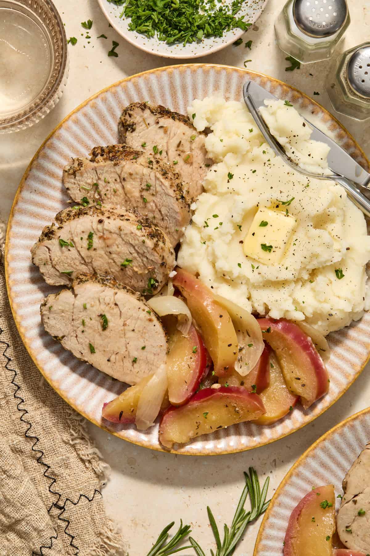 Plate with instant pot pork tenderloin, cooked apples and mashed potatoes.