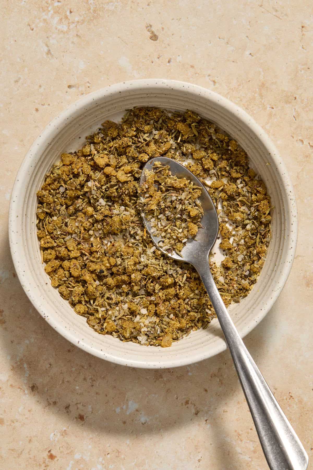 Seasonings mixed together in bowl with spoon.