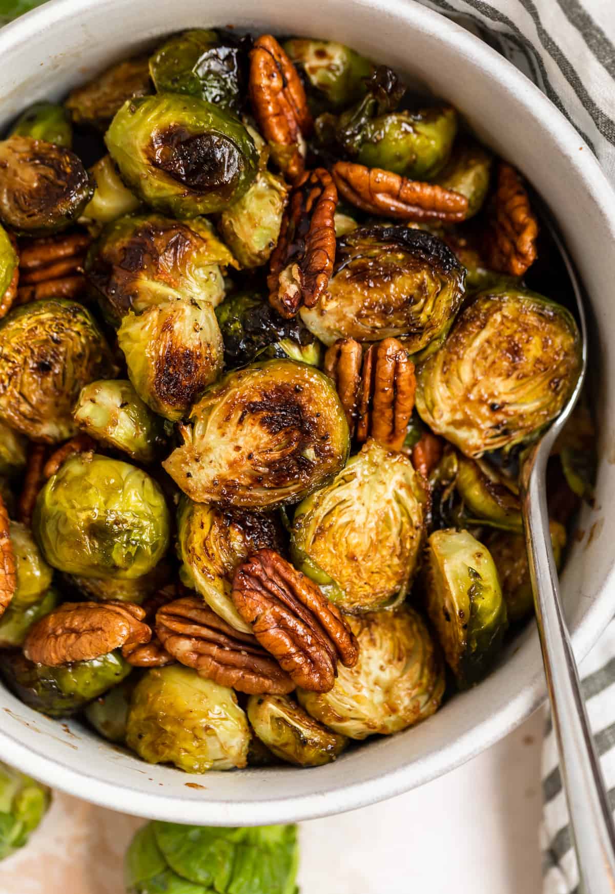 Roasted maple balsamic brussels sprouts in dish with pecans.