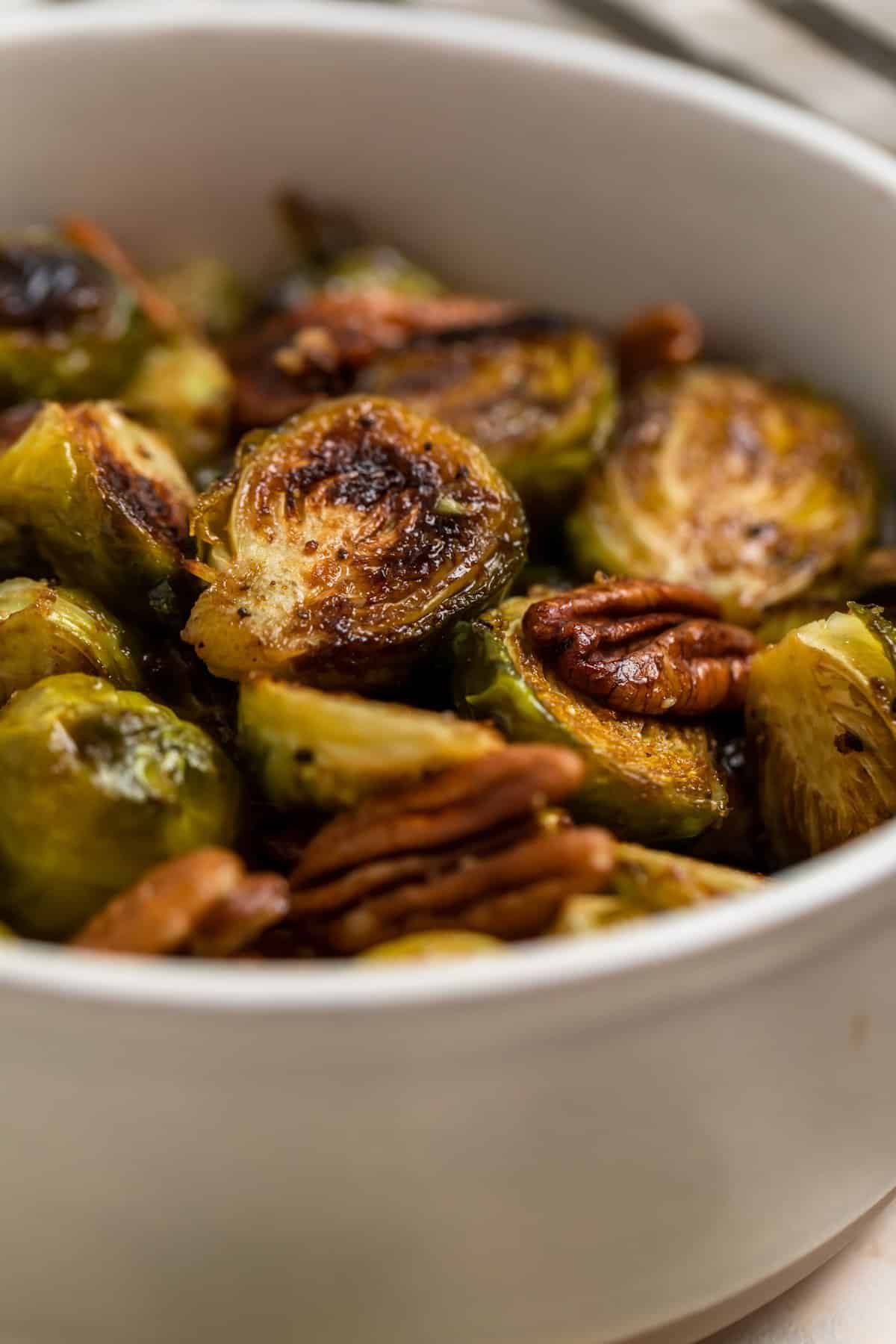 Dish with roasted brussels sprouts tossed in balsamic.