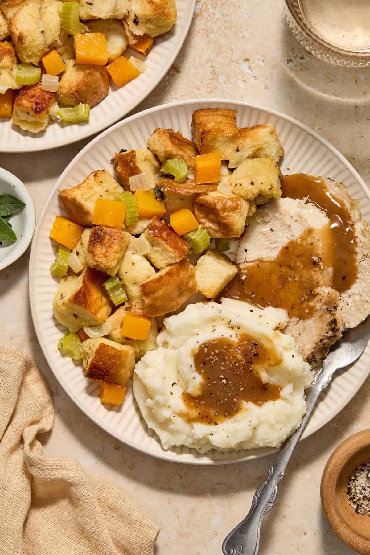 Butternut squash stuffing on plate with turkey and mashed potatoes.