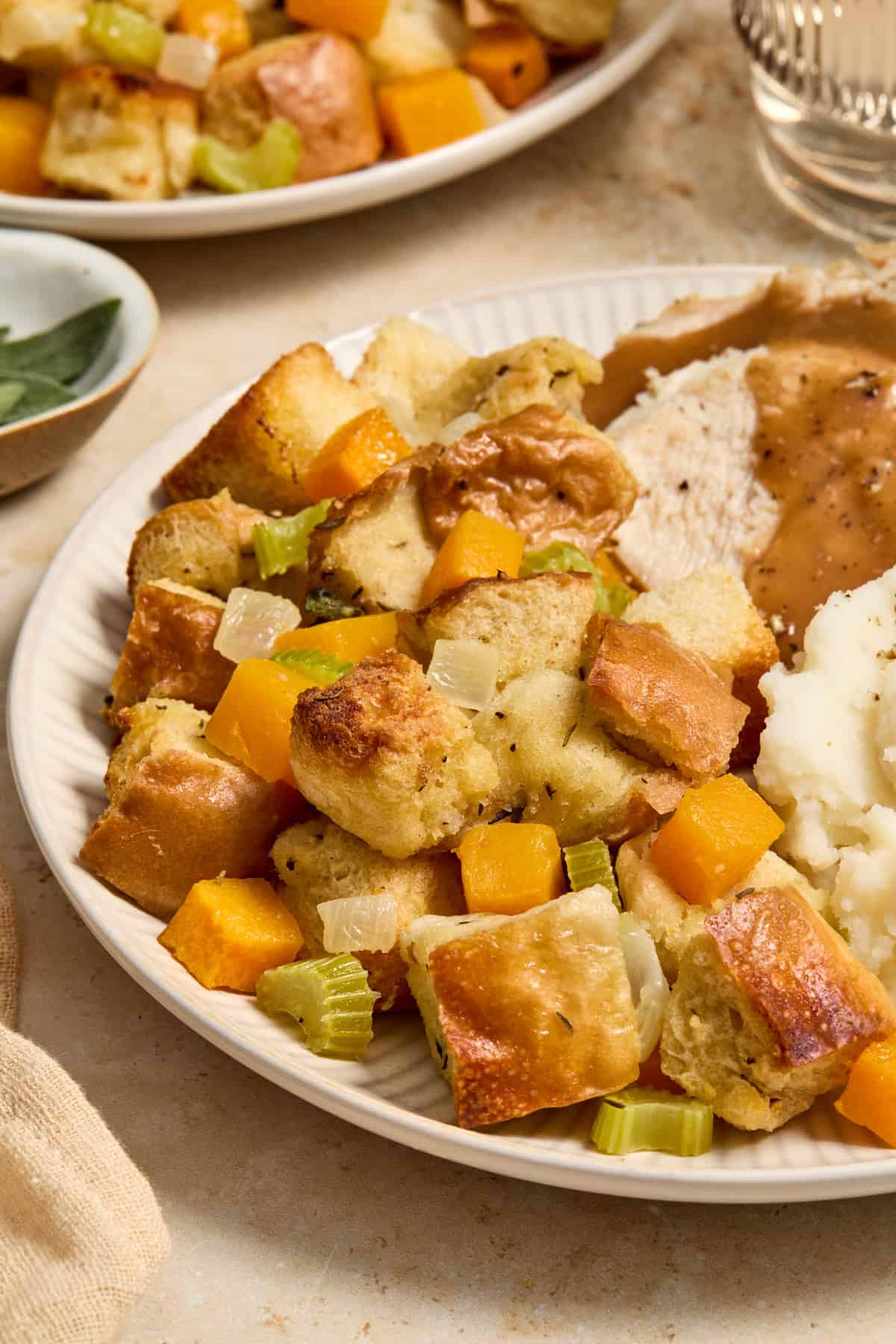 Plate with stuffing, turkey, mashed potatoes and gravy.