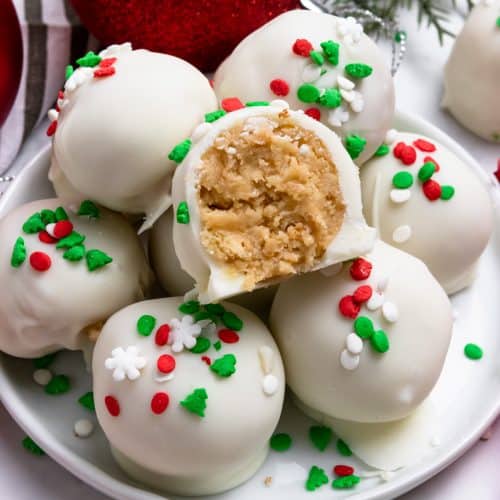 Christmas Oreo balls with Golden oreos and white coating with red and green holiday sprinkles.